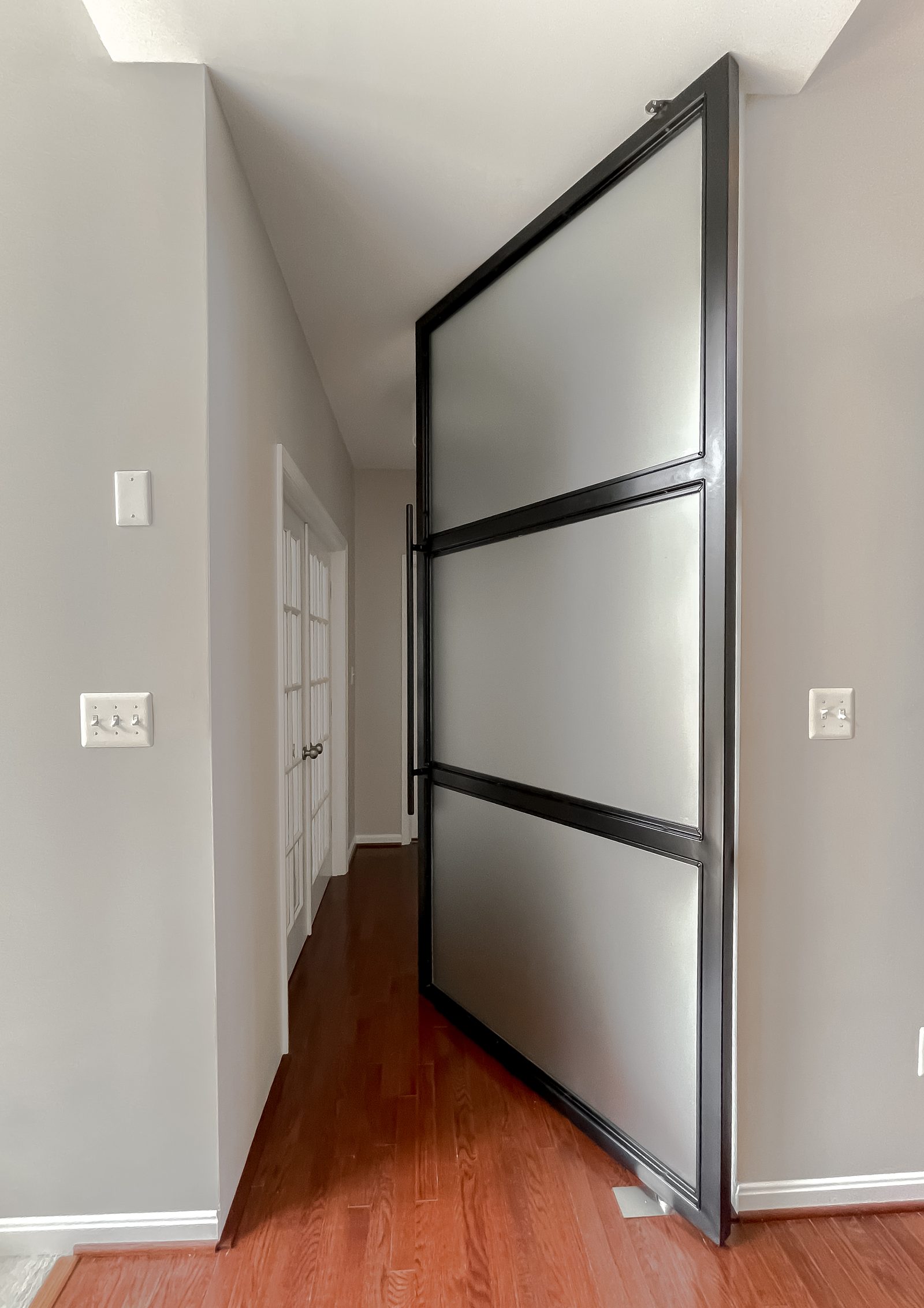 Custom pivot door in the builder-grade to luxury bathroom remodel